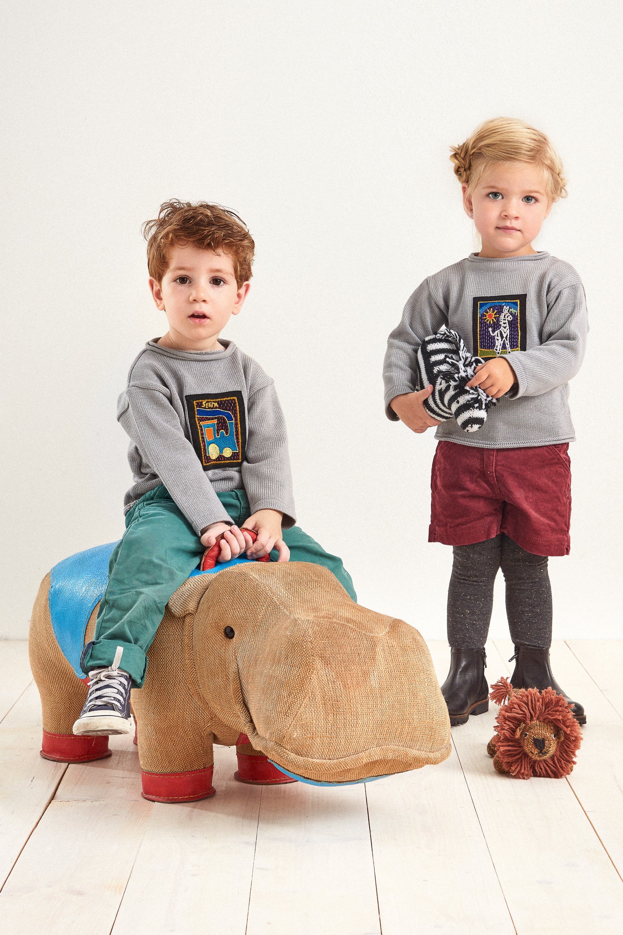 Kinder-Pullover mit handgesticktem Afrika-Motiv, gehalten von einem Kind.